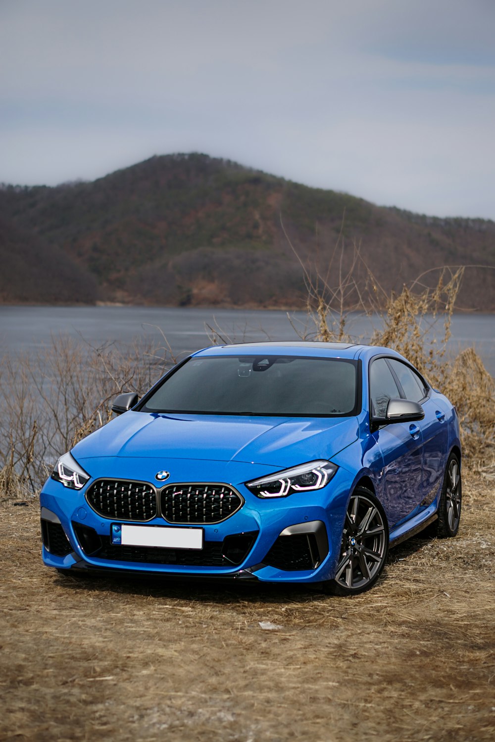 blue bmw m 3 on brown field during daytime