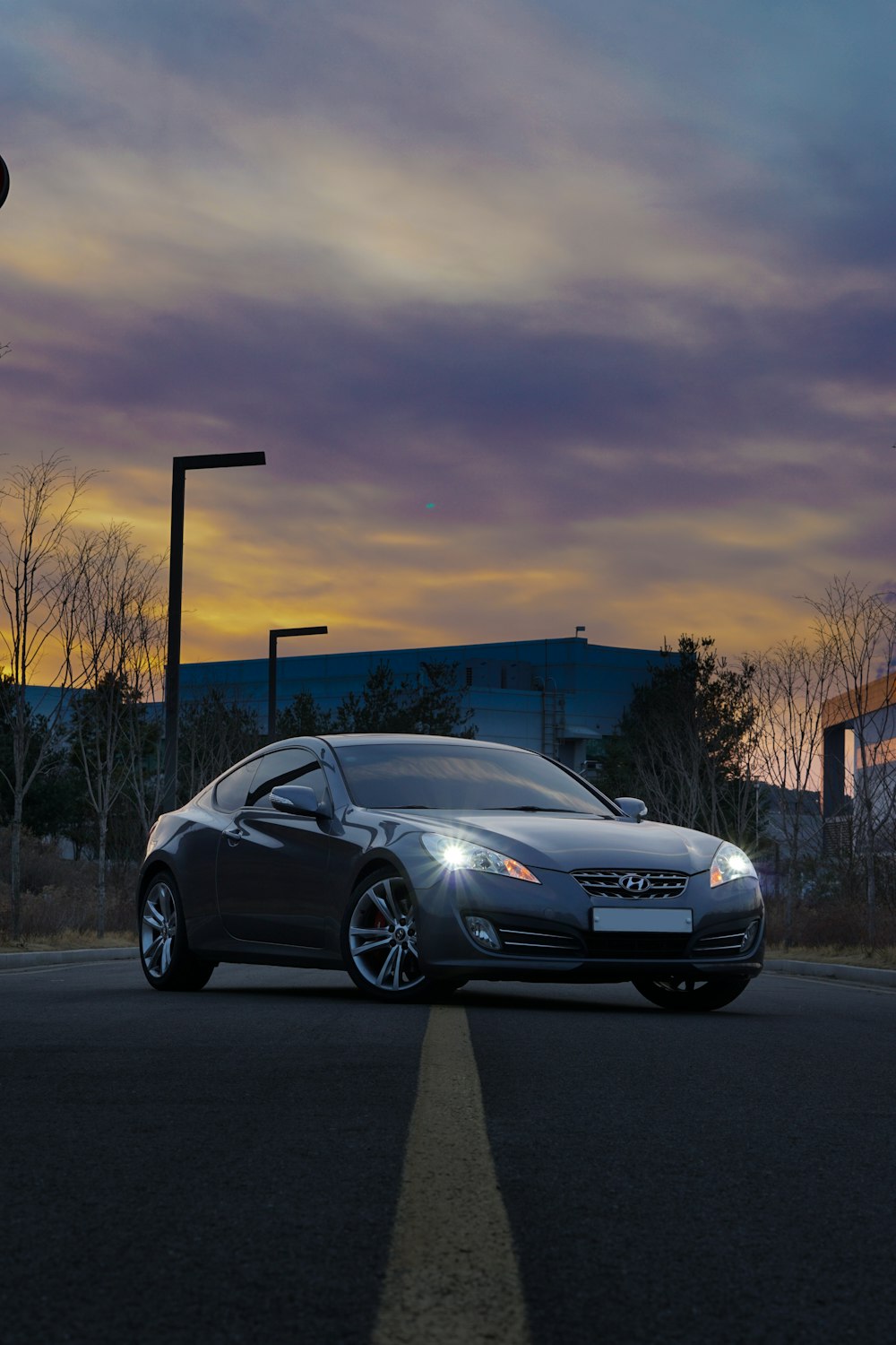 Porsche 911 argentée garée sur le parking au coucher du soleil