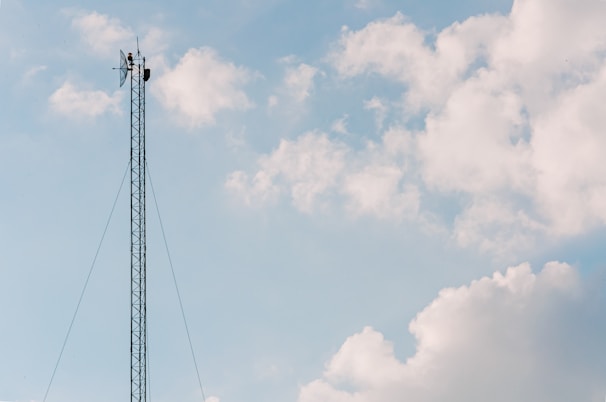 black electric post under cloudy sky during daytime