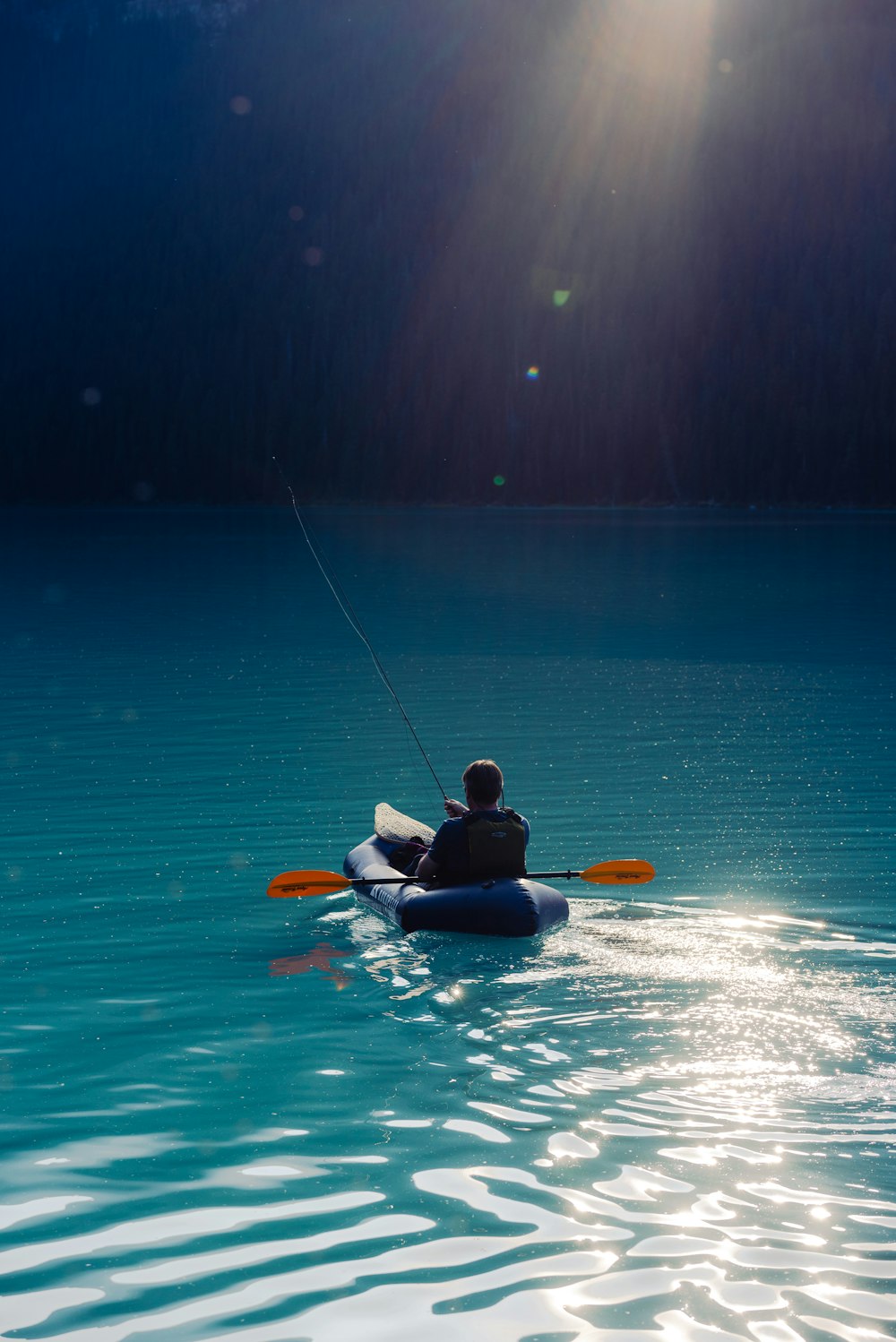 person riding on kayak on body of water during daytime