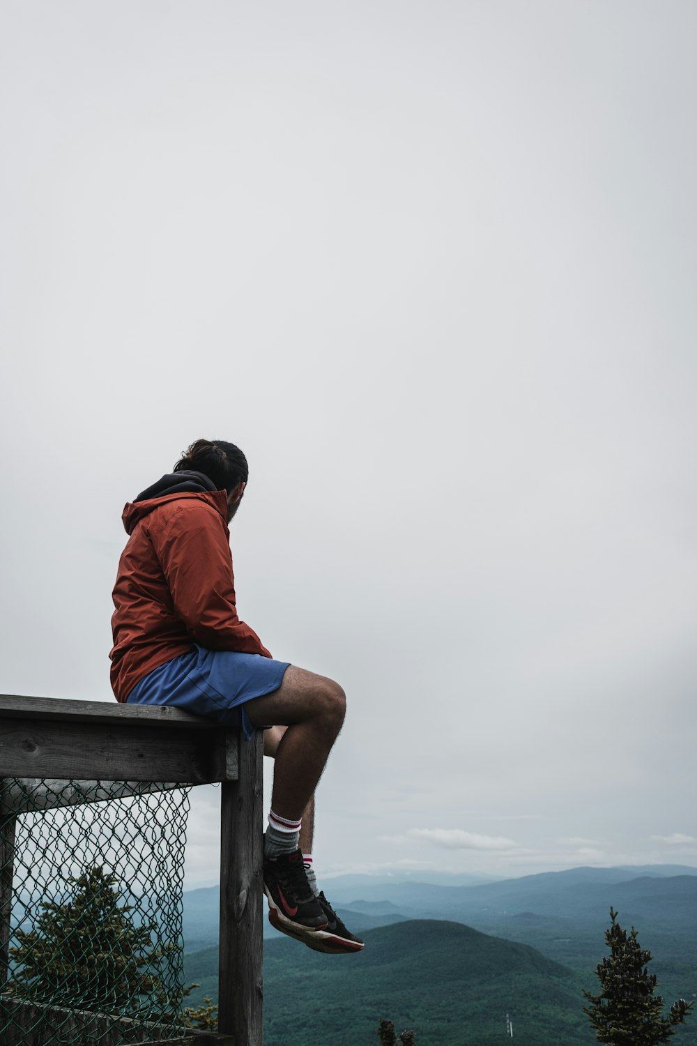 a man sitting on top of a wooden bench