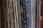 A collection of vinyl records is lined up vertically, with their spines displaying various album and artist names. The records appear tightly packed together, with a mix of modern and classic albums visible. The spines are colorful, indicating a diverse assortment of music genres.