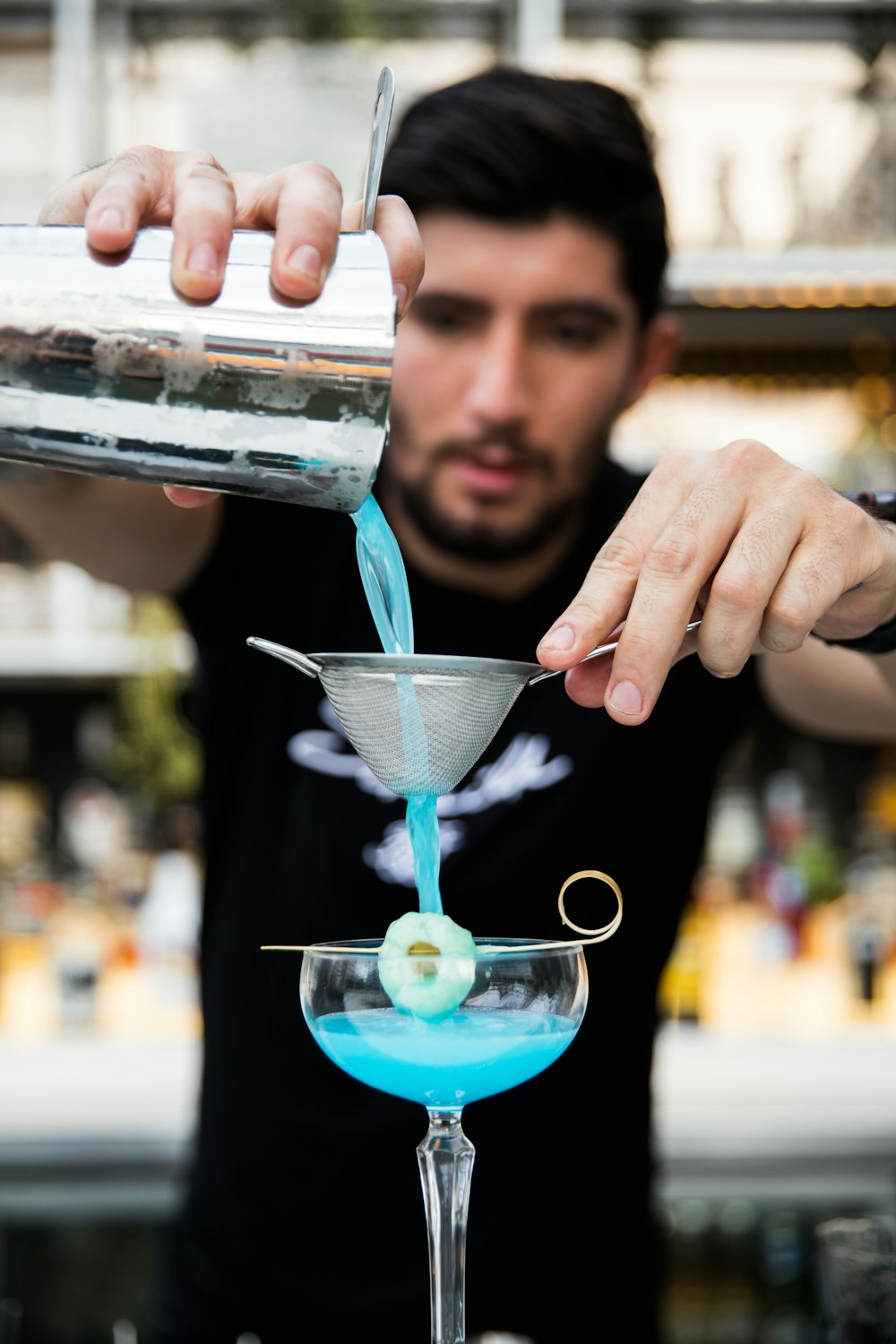 femme tenant une tasse en verre transparent avec un liquide bleu