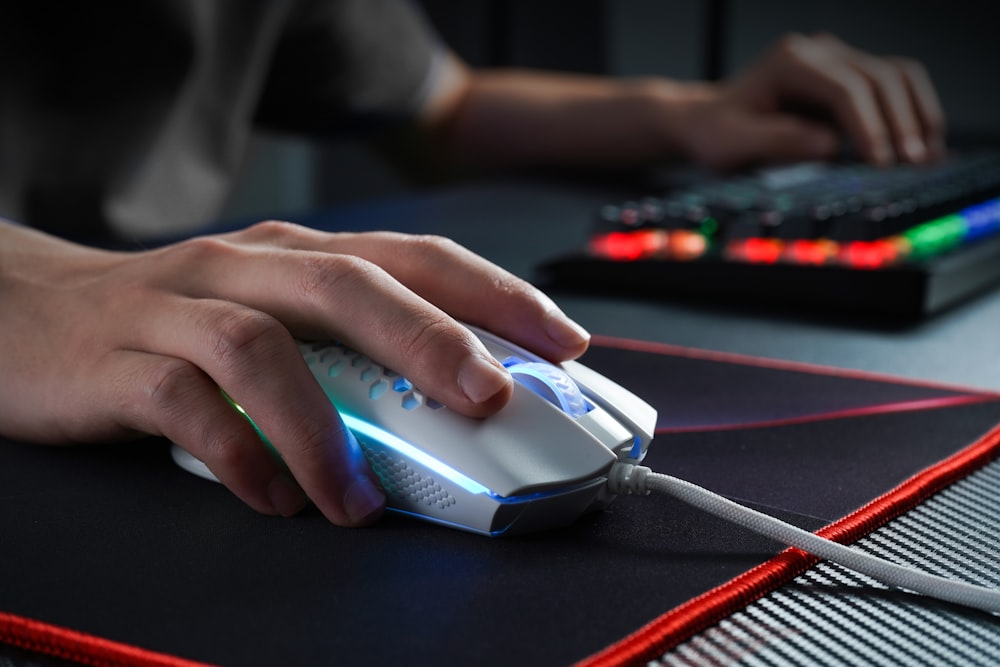 Persona che tiene il mouse del computer nero e grigio