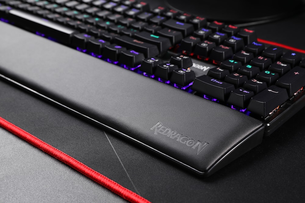 black computer keyboard beside red pencil