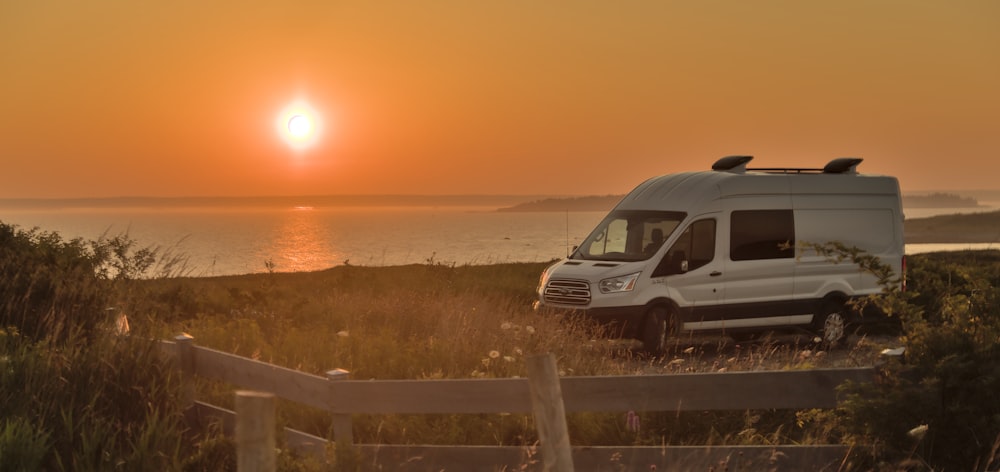 white van on beach during sunset