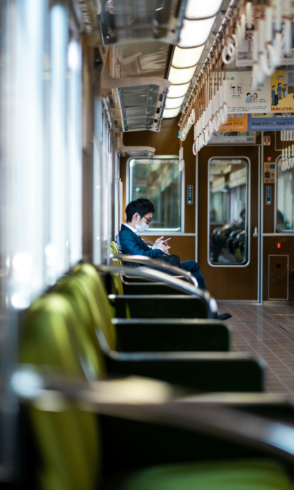 hombre con camisa de vestir azul sentado en el asiento del tren