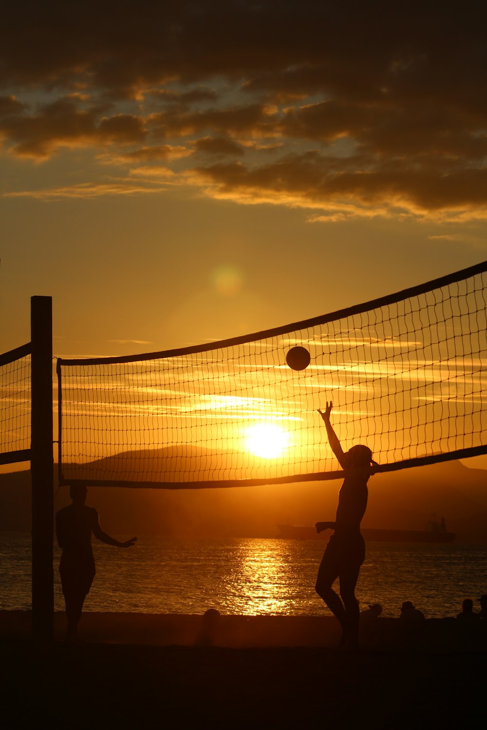 silhouette of man playing volleyball during sunset