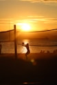 silhouette of man playing soccer during sunset
