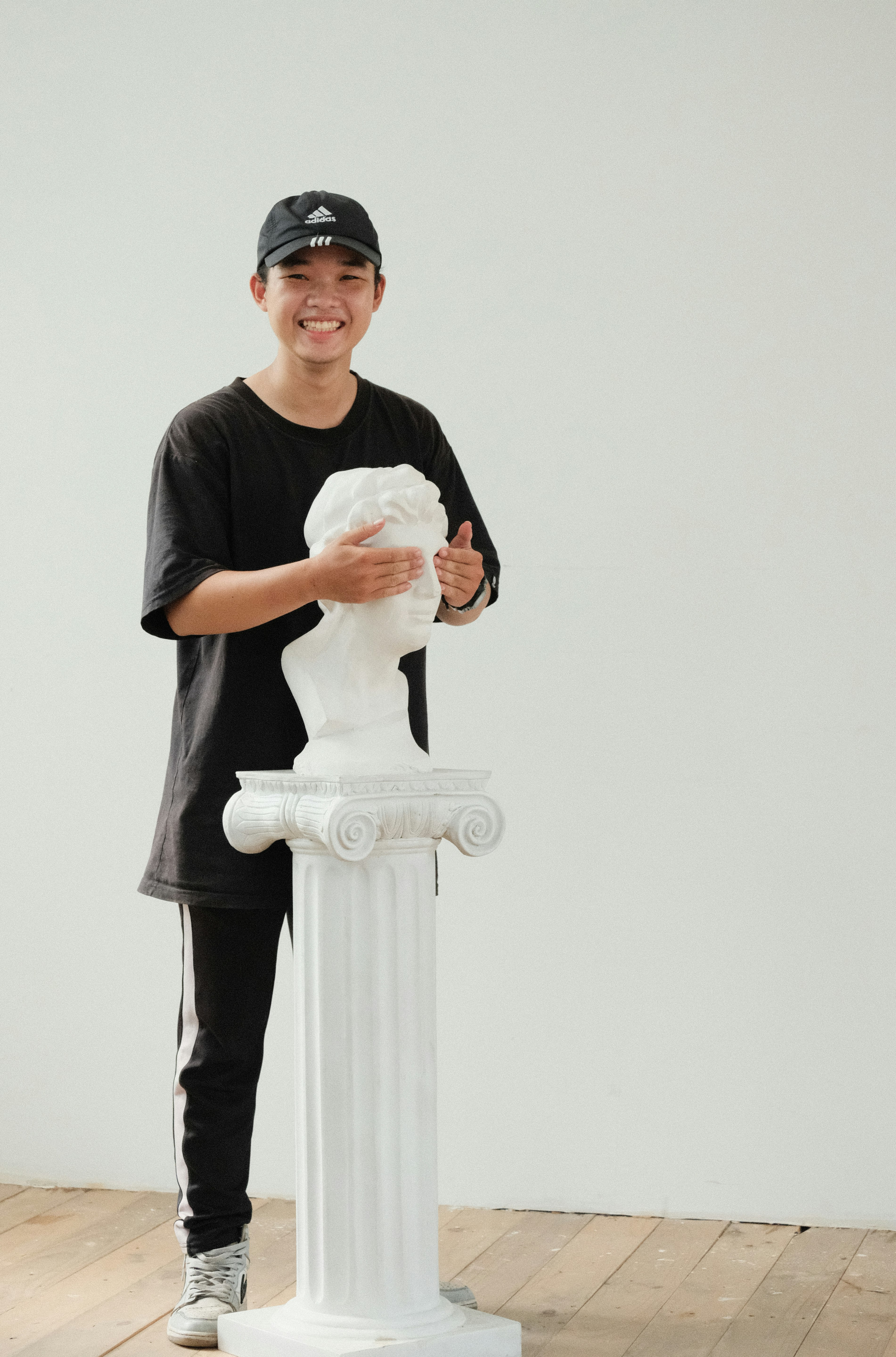 man in black crew neck t-shirt holding white angel statue