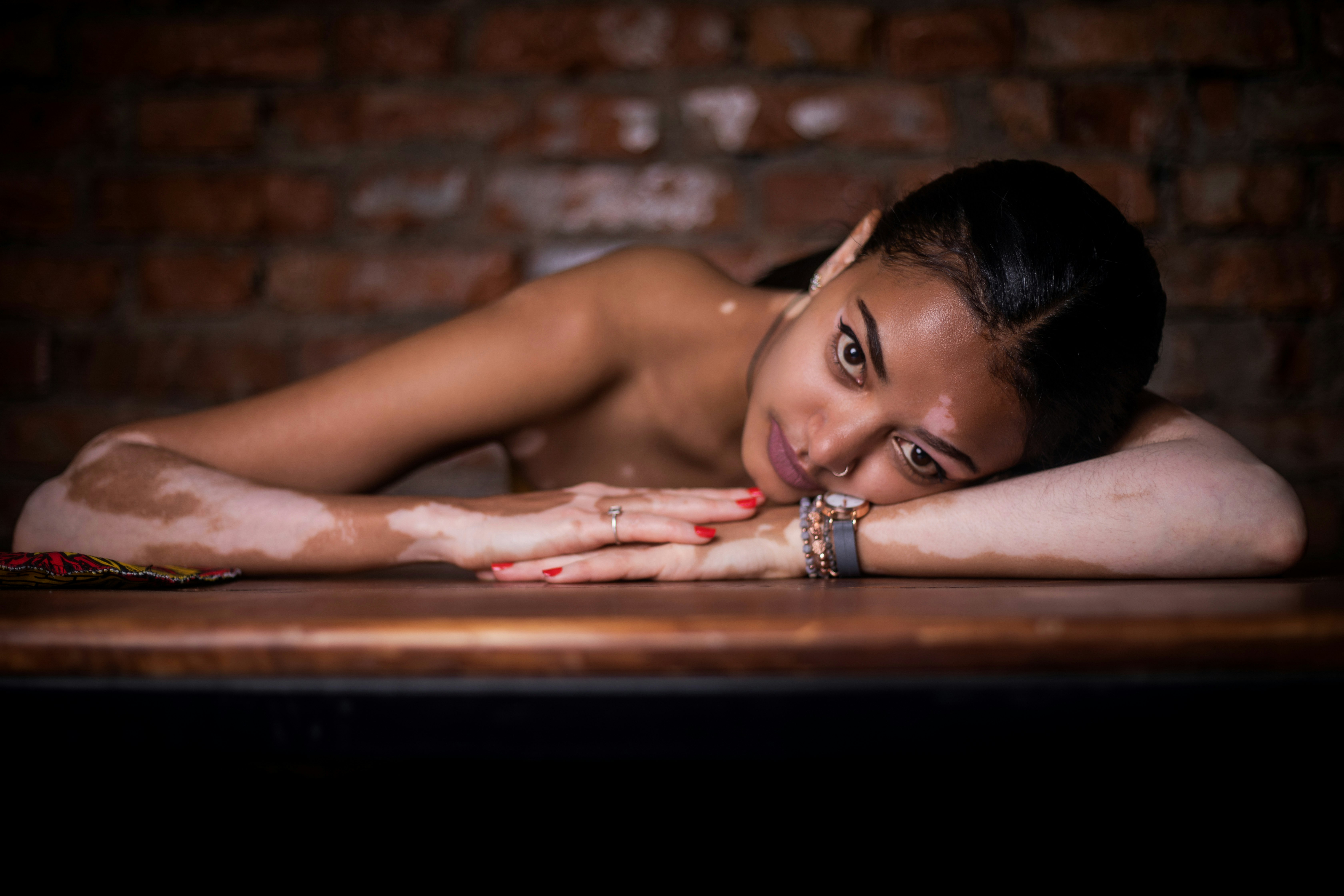 topless woman lying on brown wooden bed