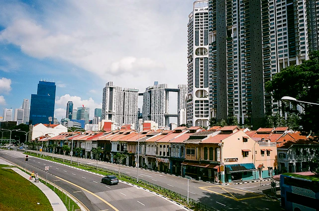 A vibrant cityscape of Singapore blending modern skyscrapers with traditional shophouses under a clear sky