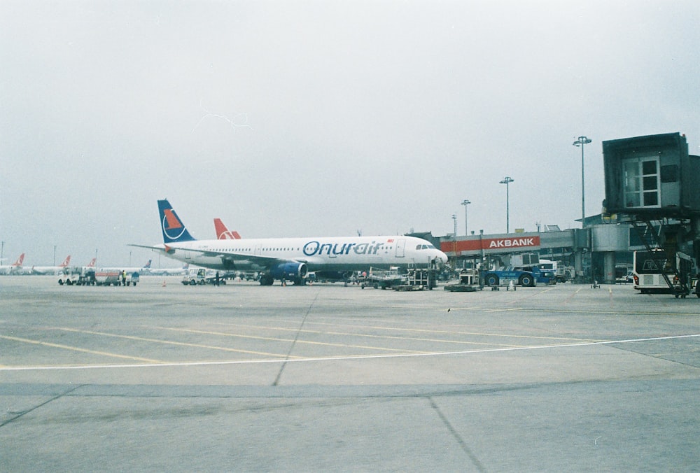 昼間の空港の白と赤の旅客機
