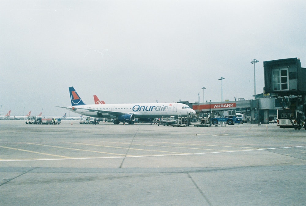 white and red passenger plane on airport during daytime