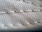 Detailed shot of durable stitching on bedding, emphasizing quality and resistance to pilling.