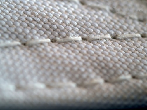 Close-up of textured fabric and detailed stitching on clothing.