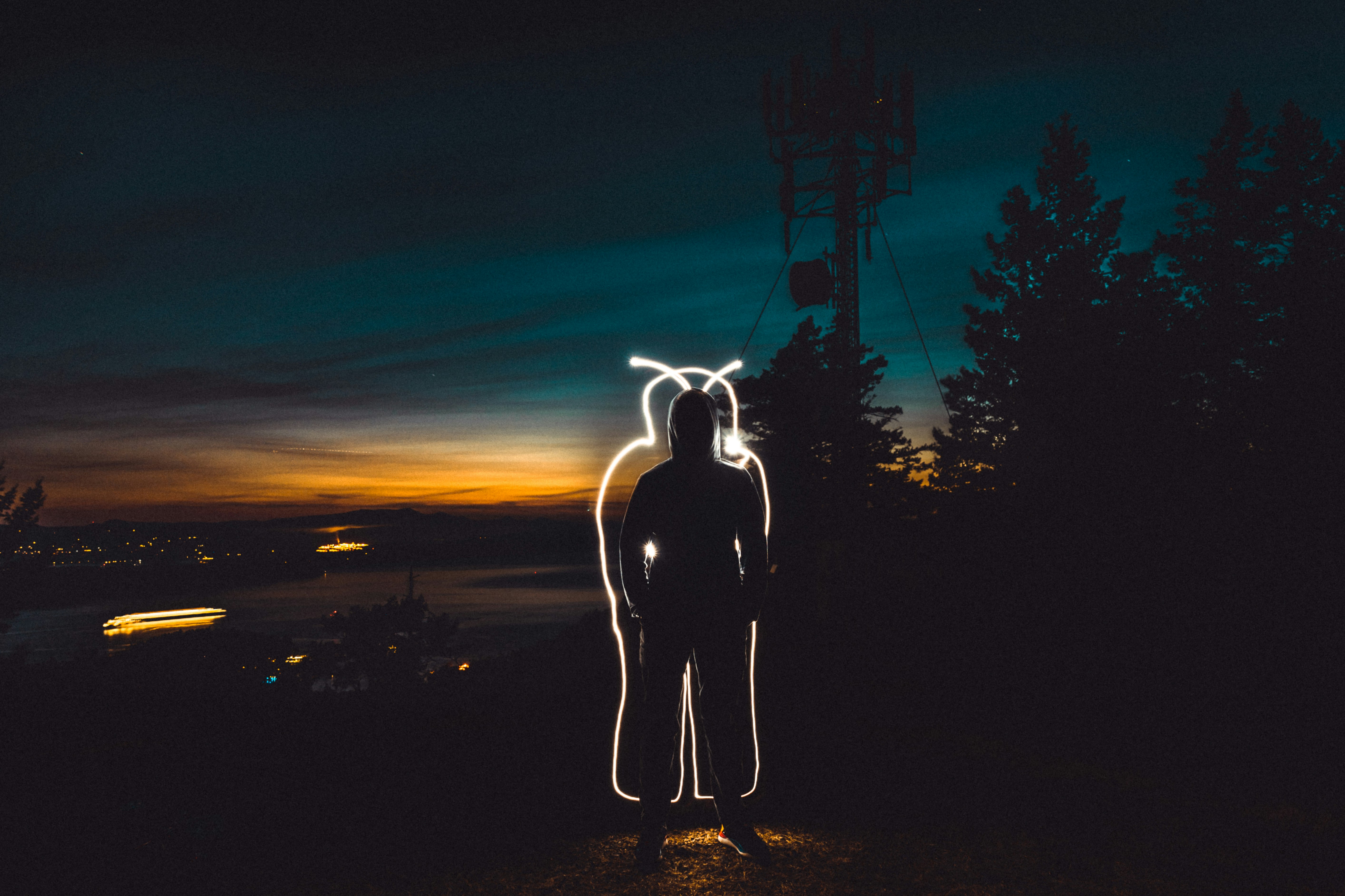 man in black jacket standing on brown sand during night time