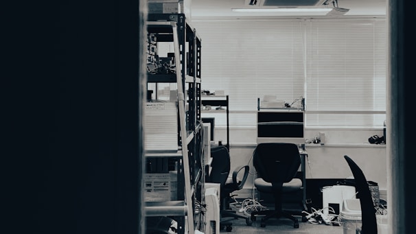Wide shot of the office workspace with computers and shelves filled with files