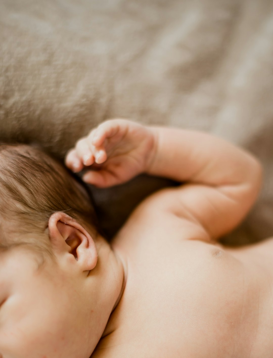 baby lying on gray textile