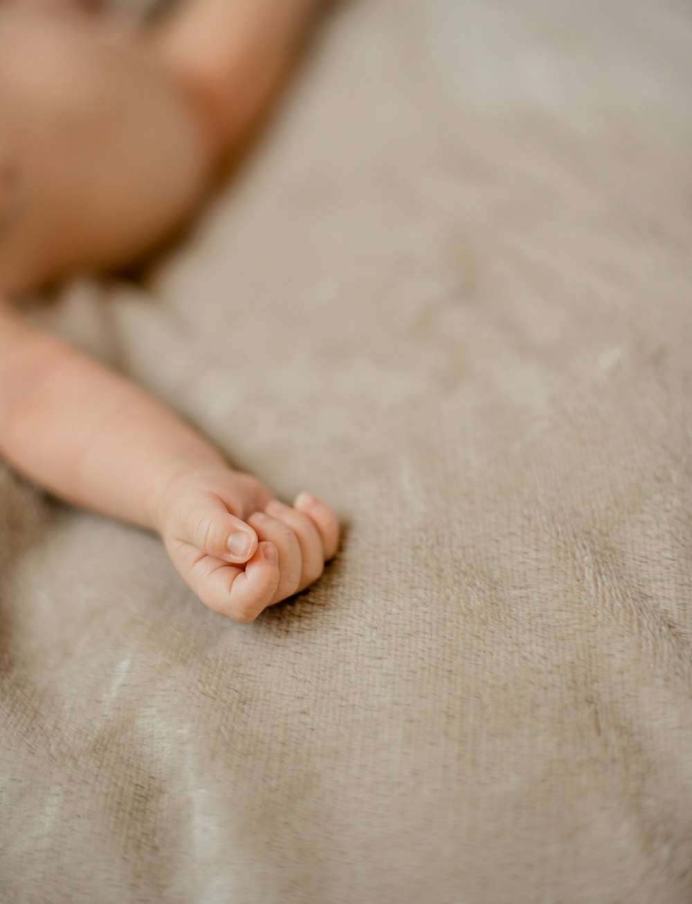 babys feet on white textile