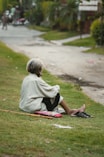 boy in white shirt sitting on ground during daytime