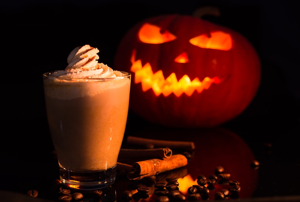 jack o lantern with chocolate drink on brown wooden table