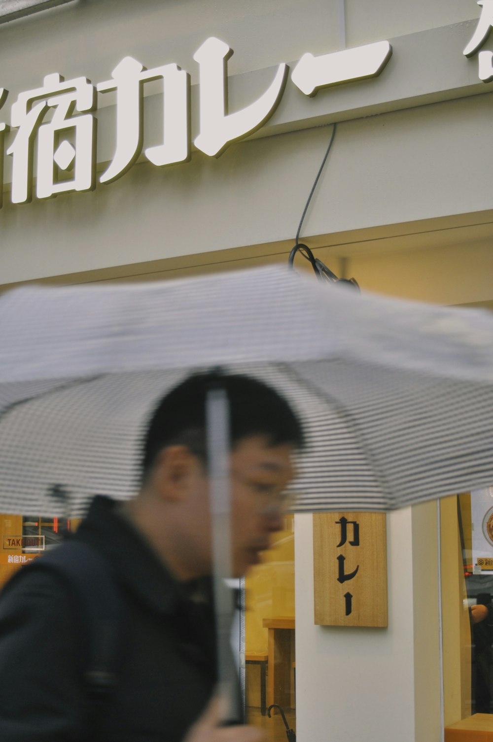 man in black jacket holding white umbrella