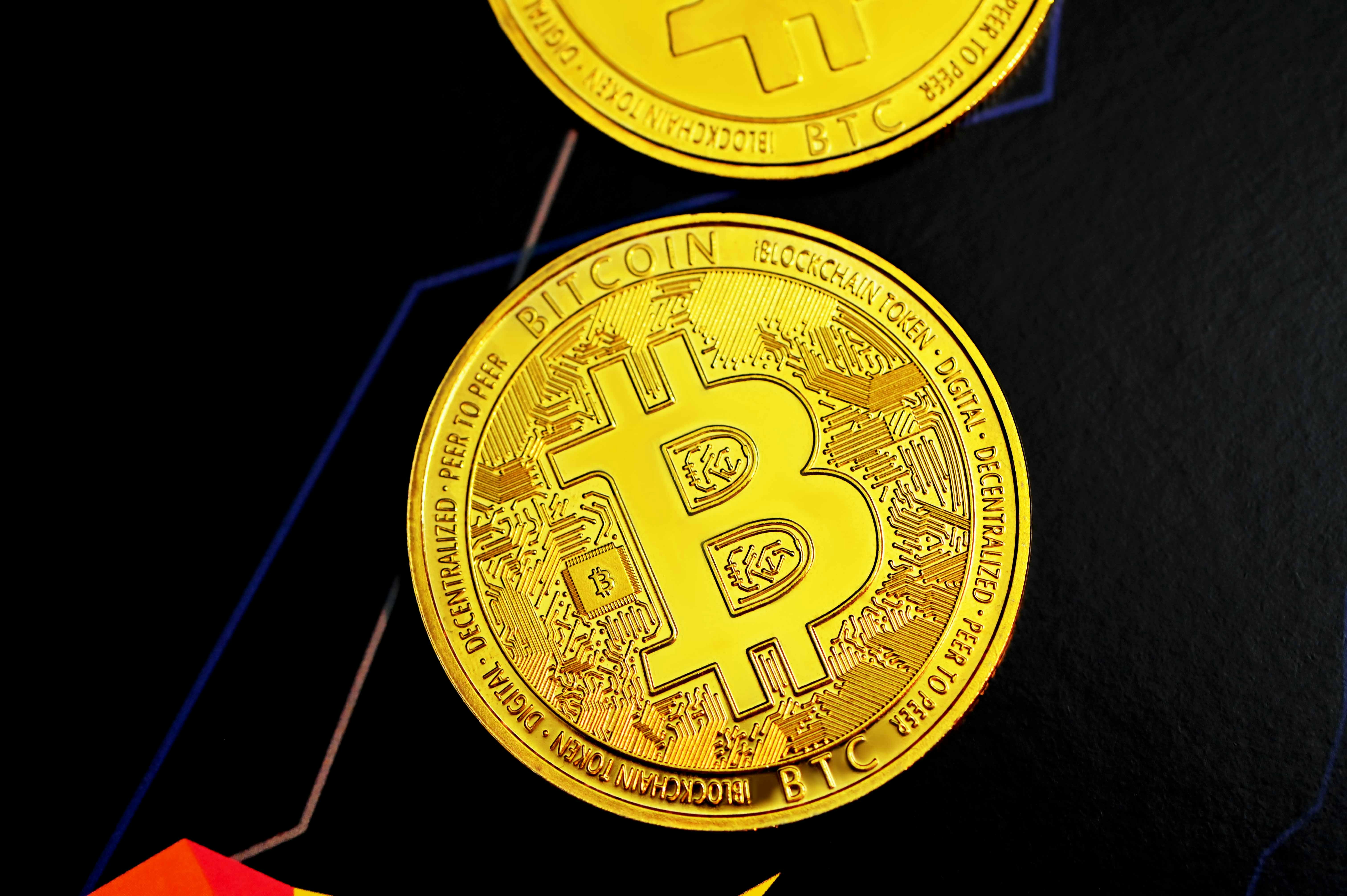 Two Bitcoins placed on a black background