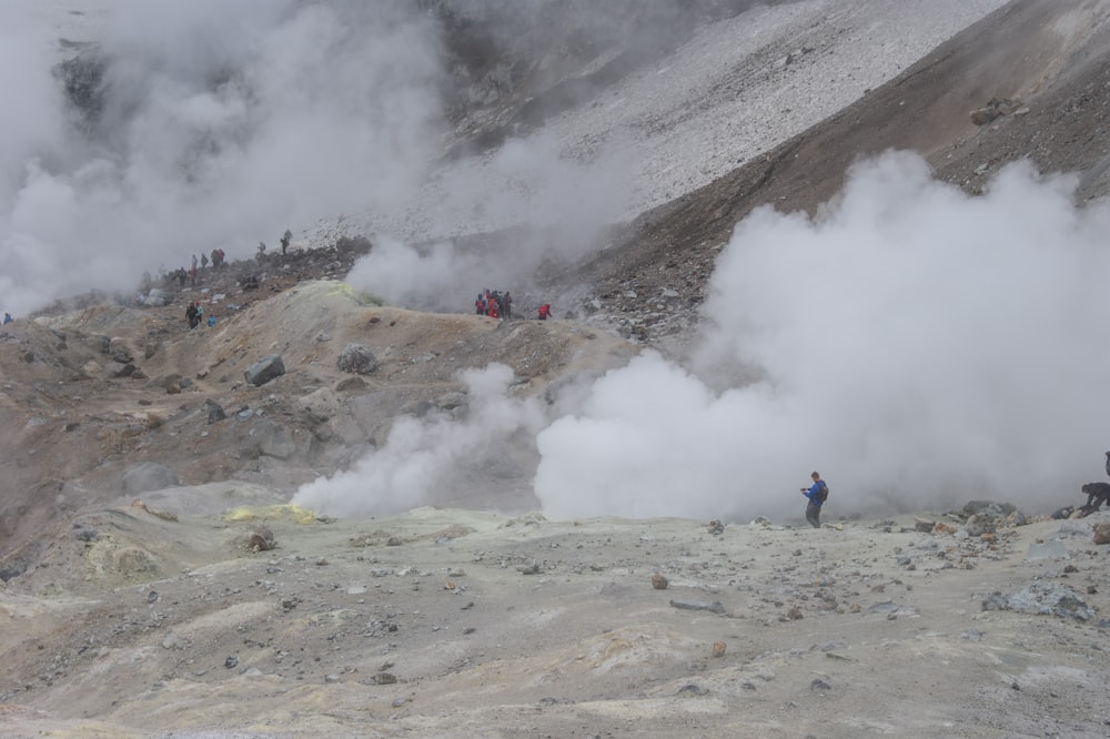 people standing on brown field near mountain during daytime