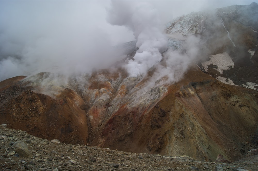 Montaña marrón cubierta de nubes blancas