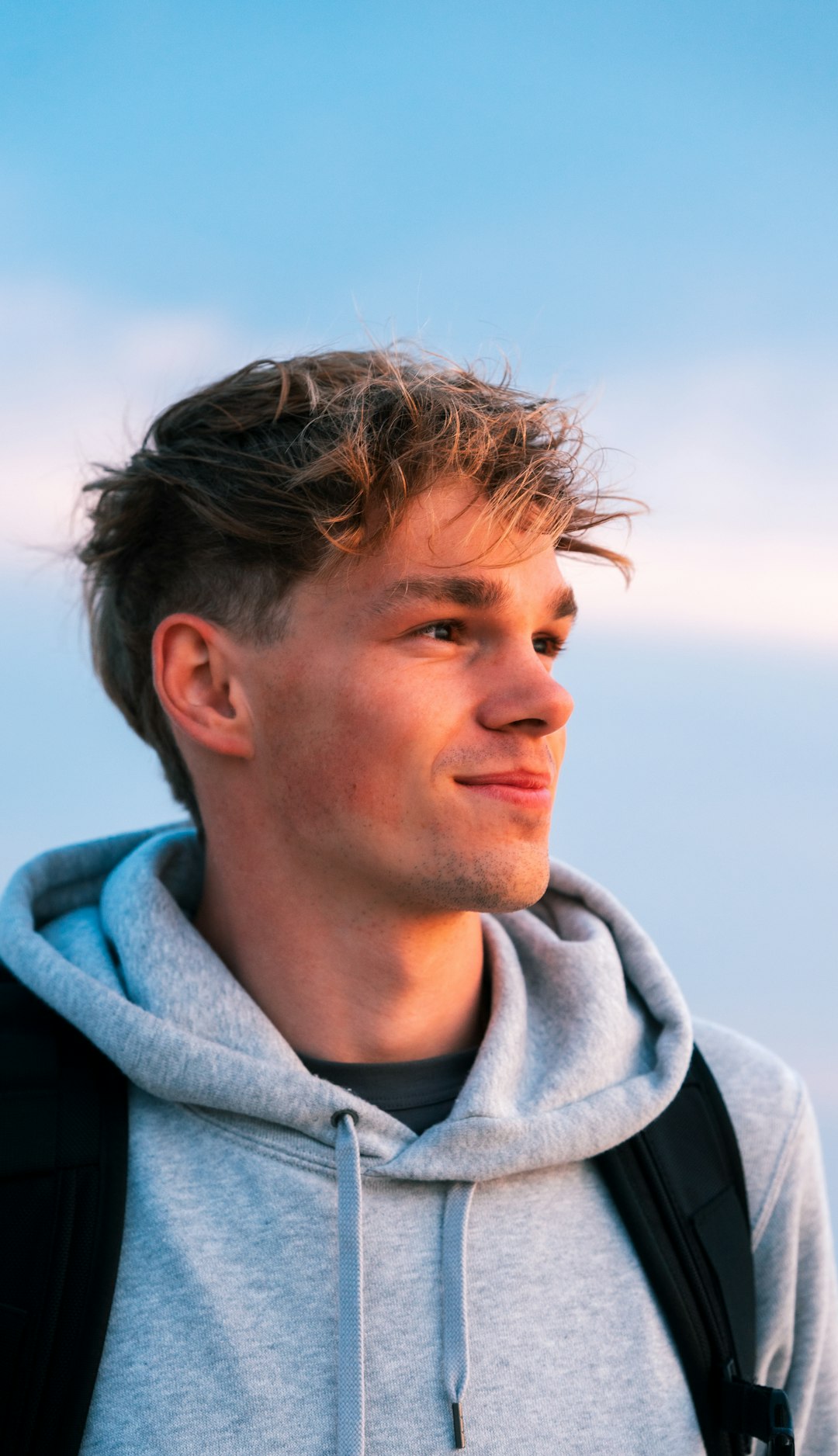 man in gray hoodie looking down