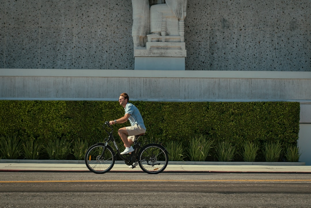 woman in white shirt riding on black bicycle during daytime