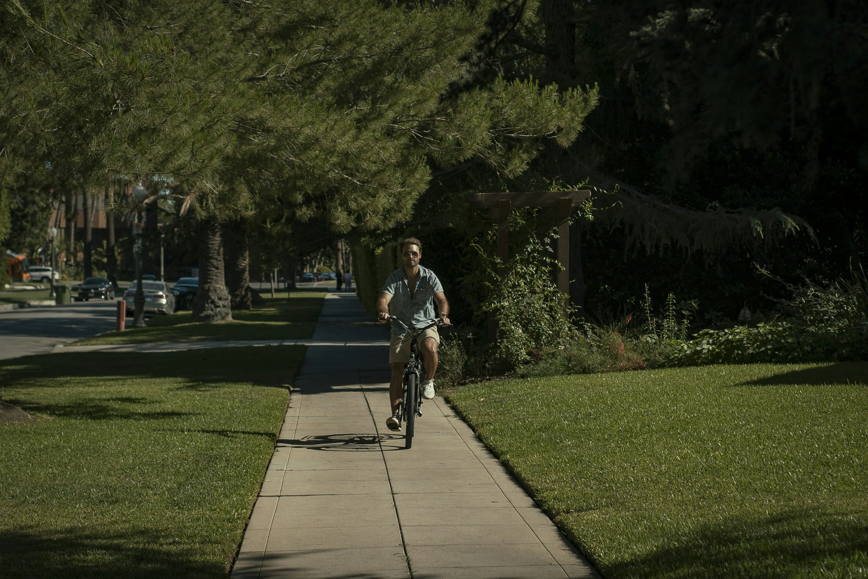 man in black t-shirt riding bicycle on gray concrete pathway during daytime