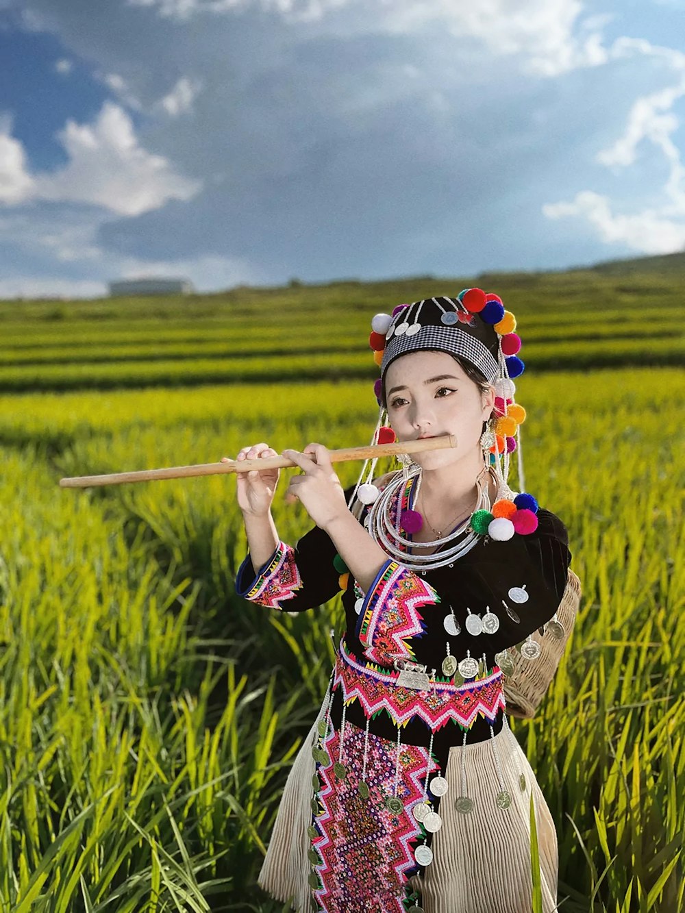 girl in black and red floral dress holding stick