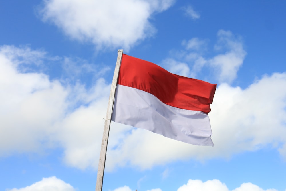 red and white flag under blue sky during daytime