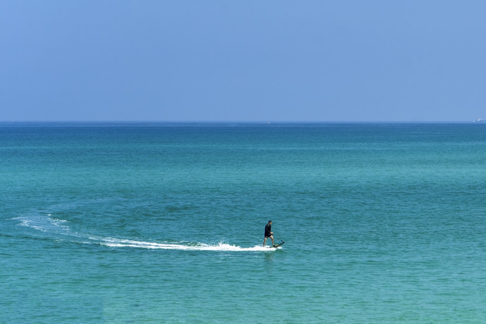 昼間、海でサーフィンをする男性