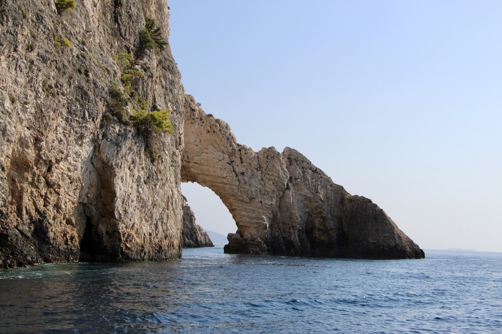 brown rock formation on blue sea under blue sky during daytime