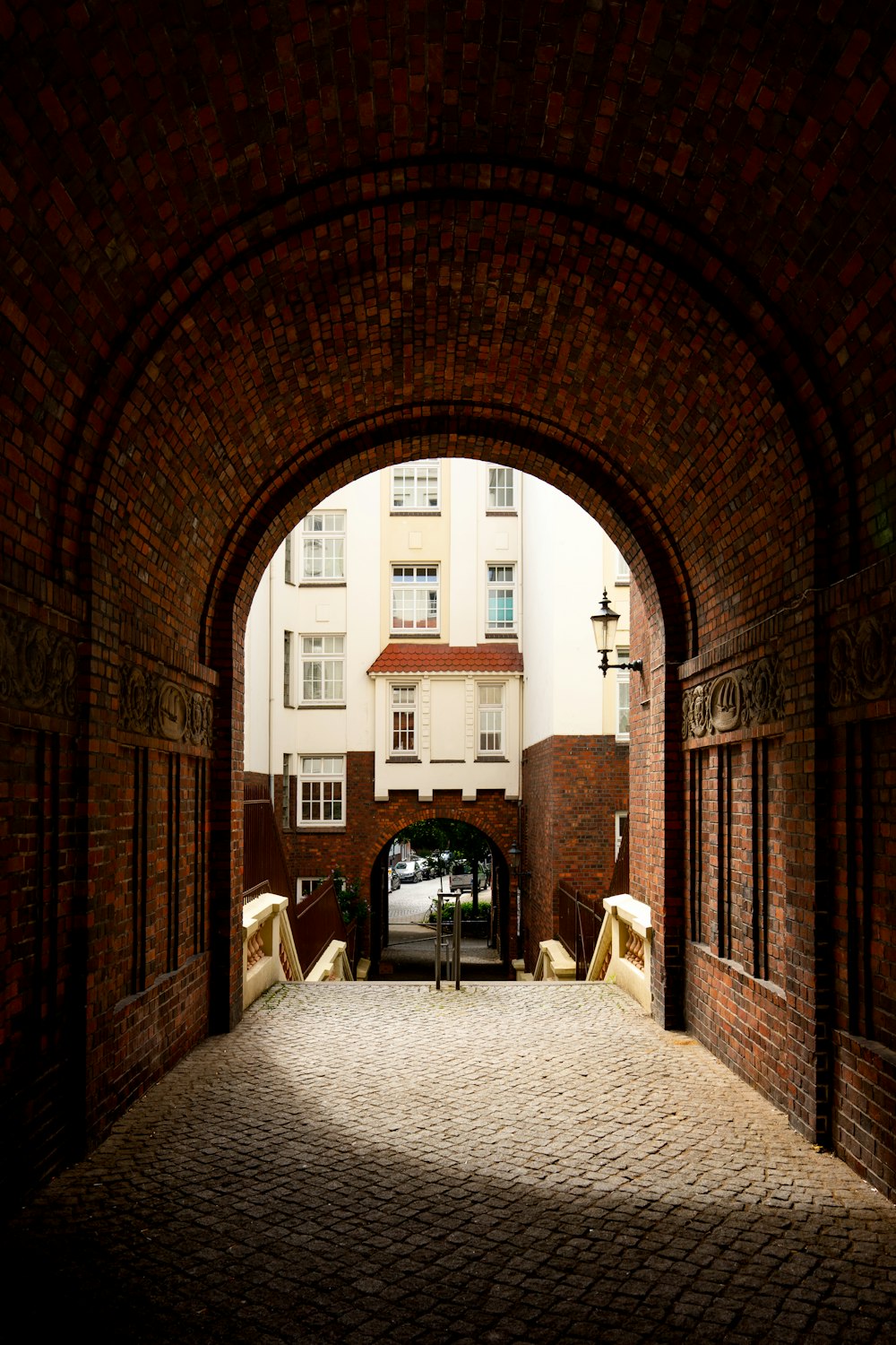 an archway leading to a building with a clock on it