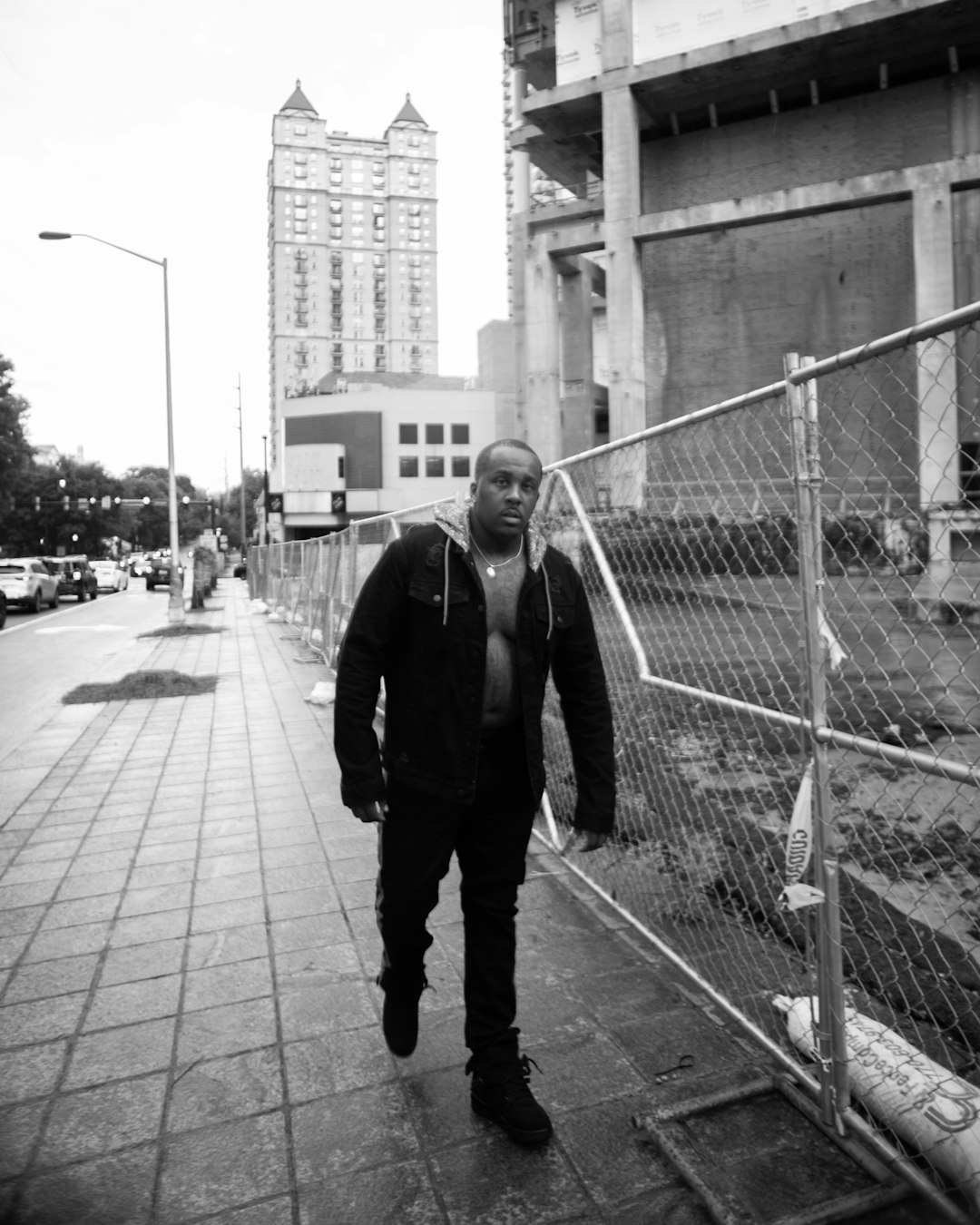 man in black jacket standing on sidewalk during daytime
