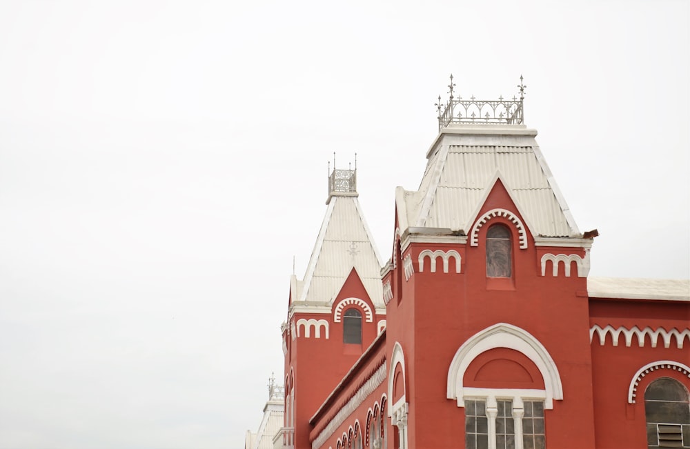 edificio in cemento rosso e bianco sotto il cielo bianco durante il giorno