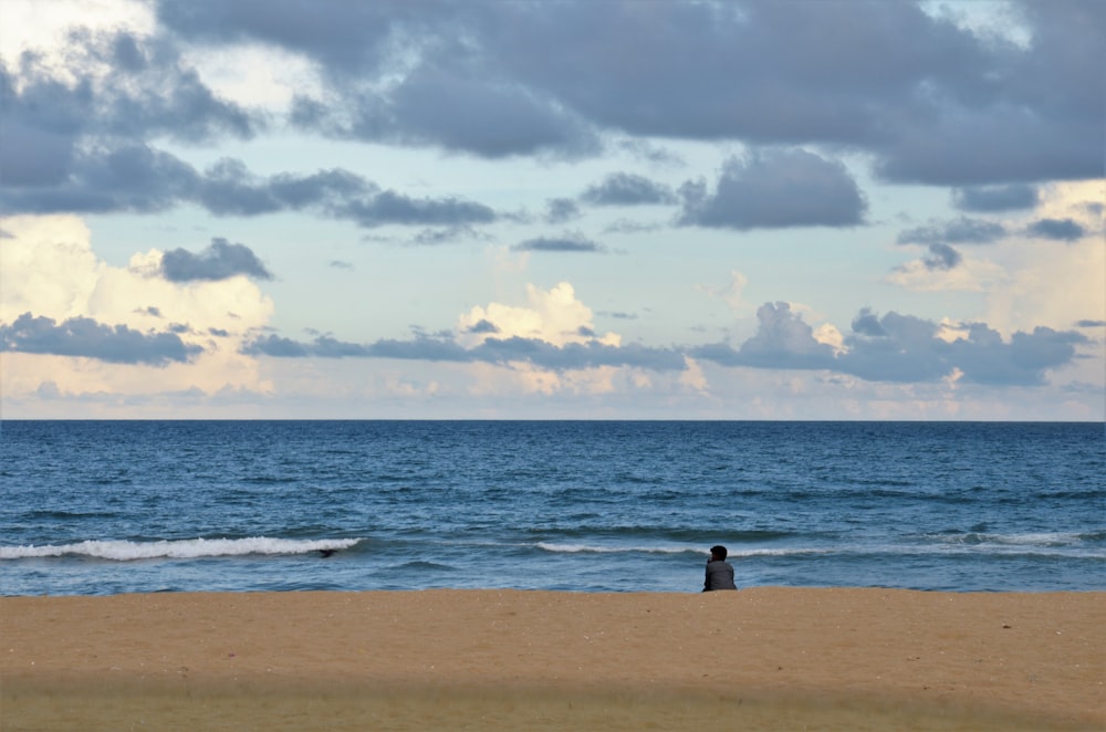 person standing on beach shore during daytime