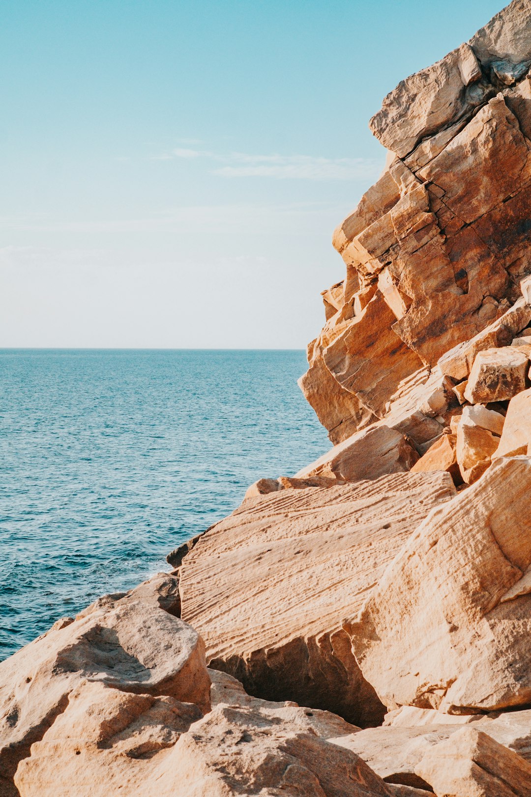 brown rock formation beside blue sea during daytime