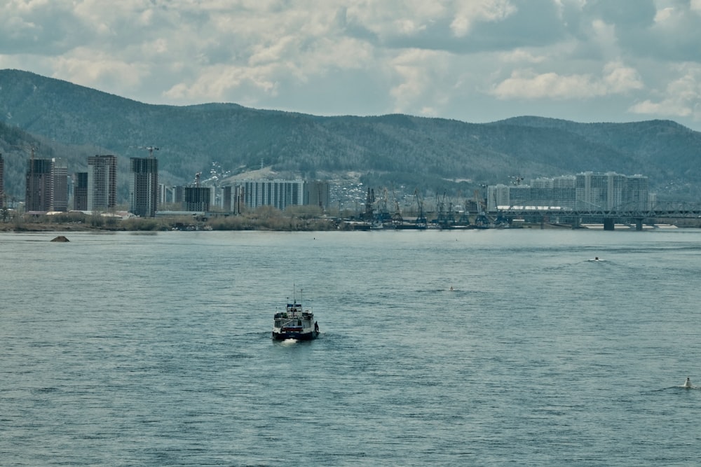 white and black boat on water near city buildings during daytime