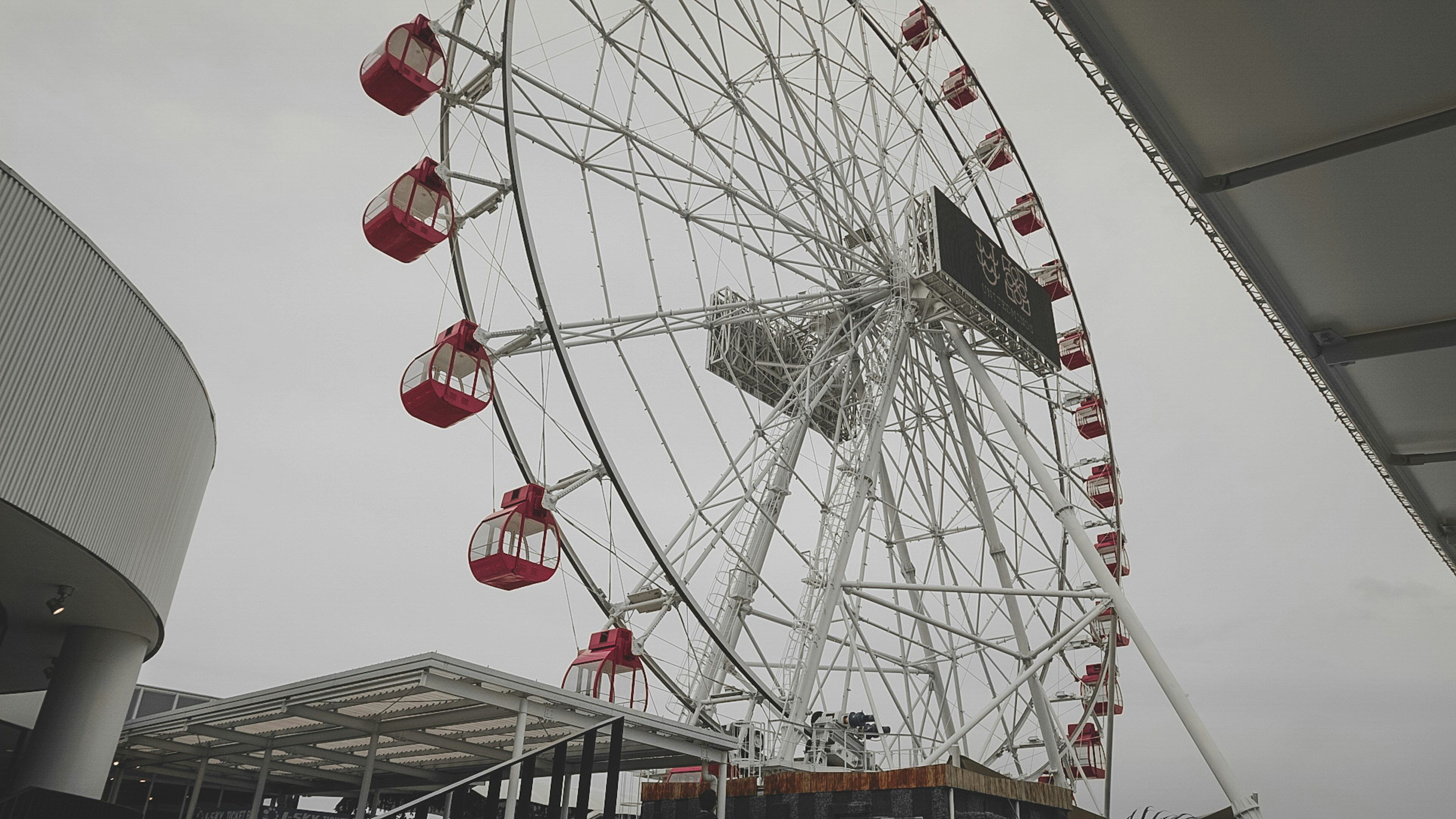 roda gigante branca e vermelha sob o céu azul durante o dia