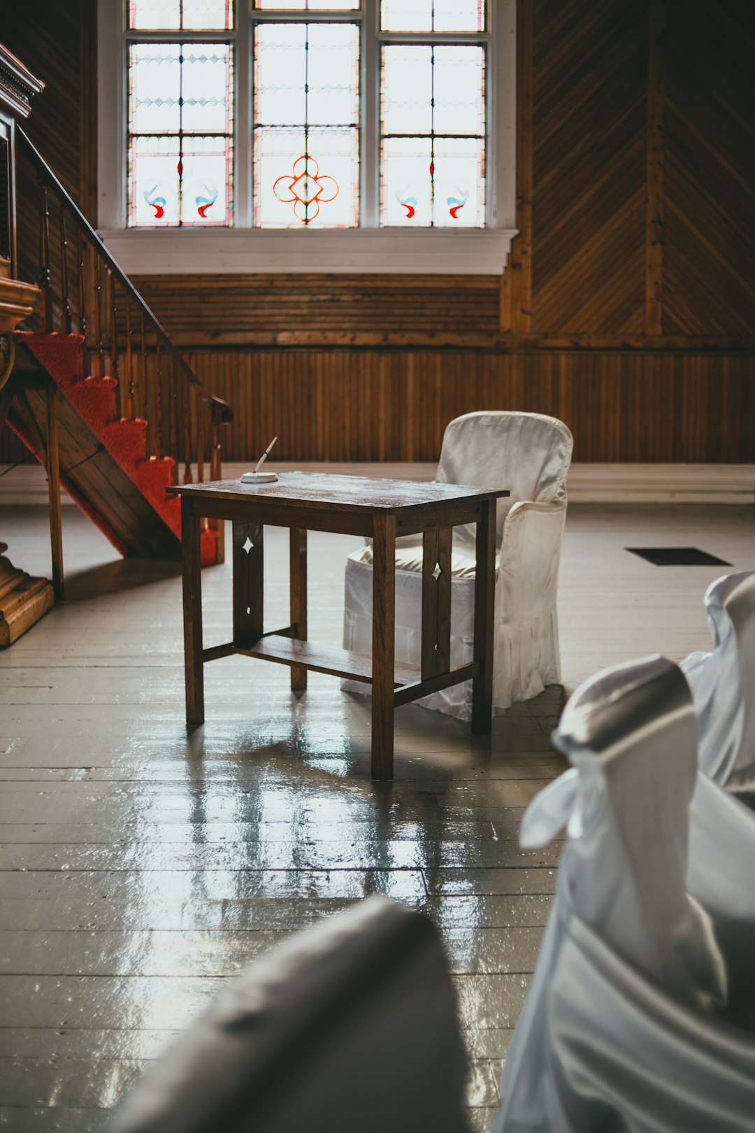 brown wooden table near white padded chair