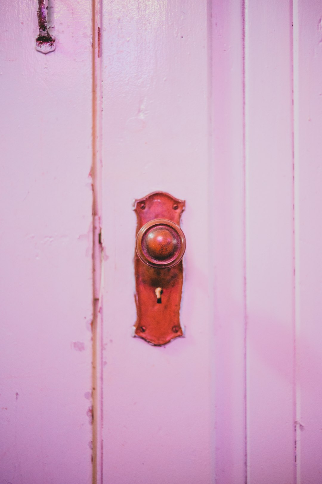 red door knob on white wooden door