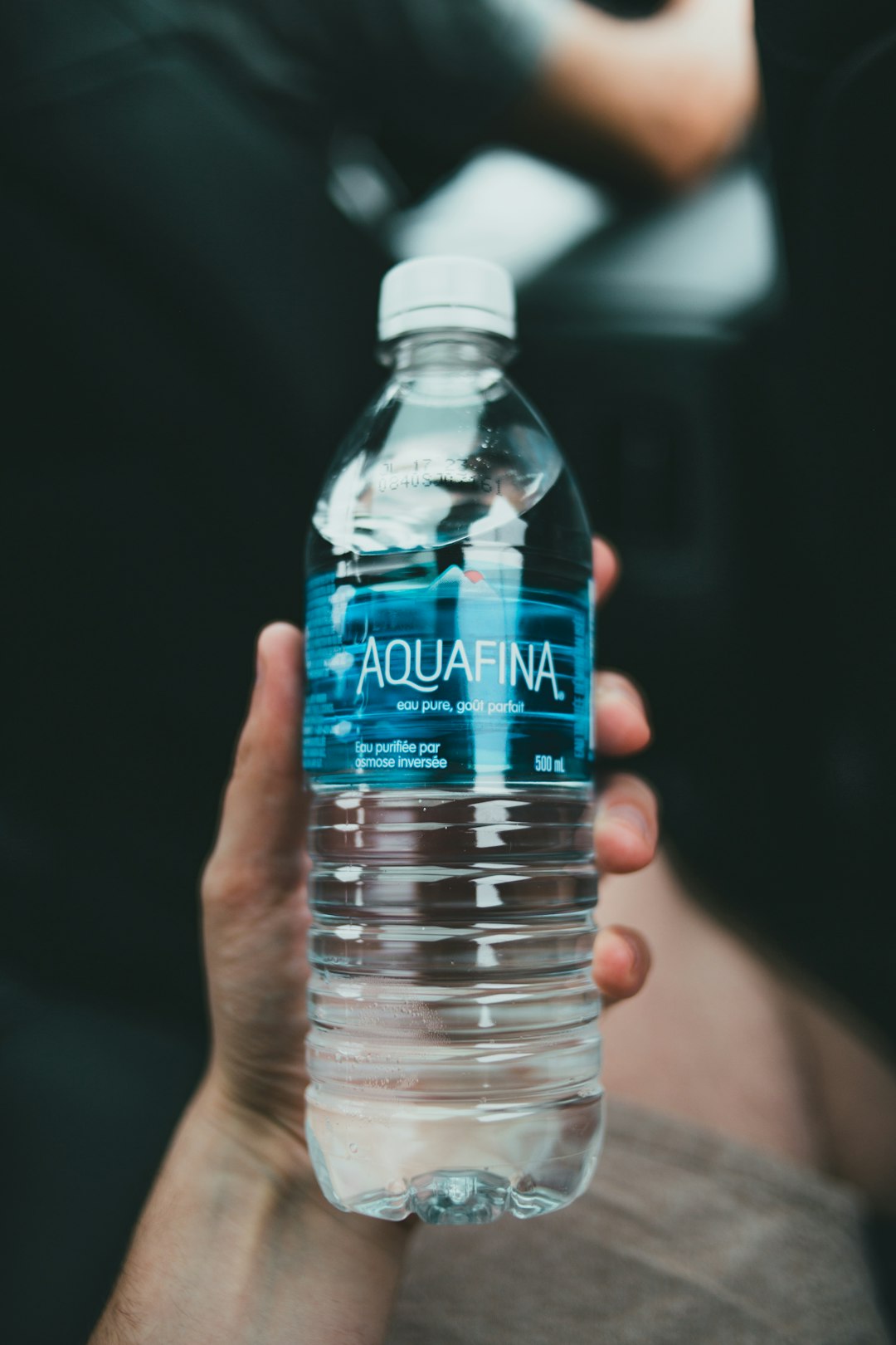 person holding clear plastic bottle