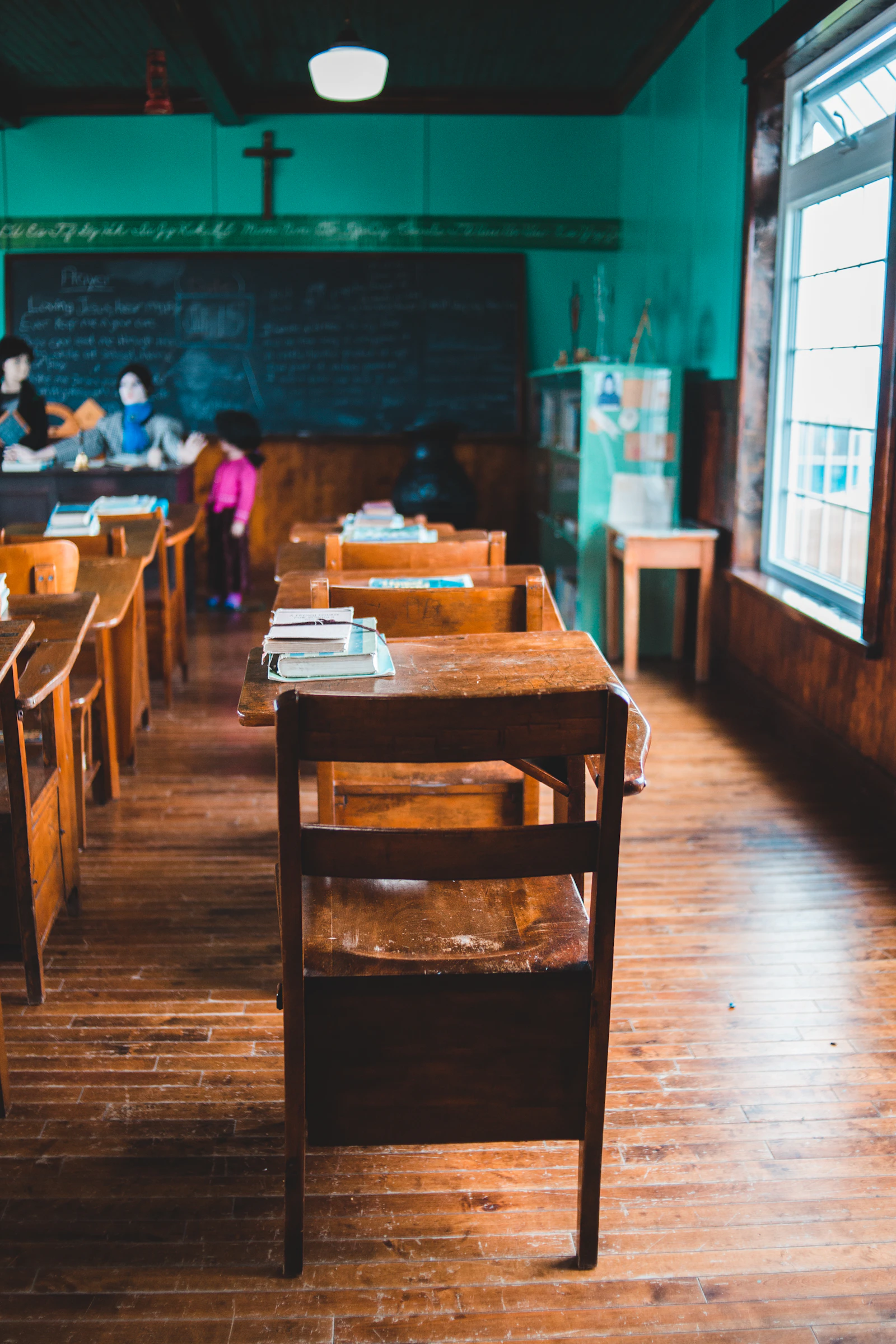 Young students seated on wooden chairs in a bright classroom