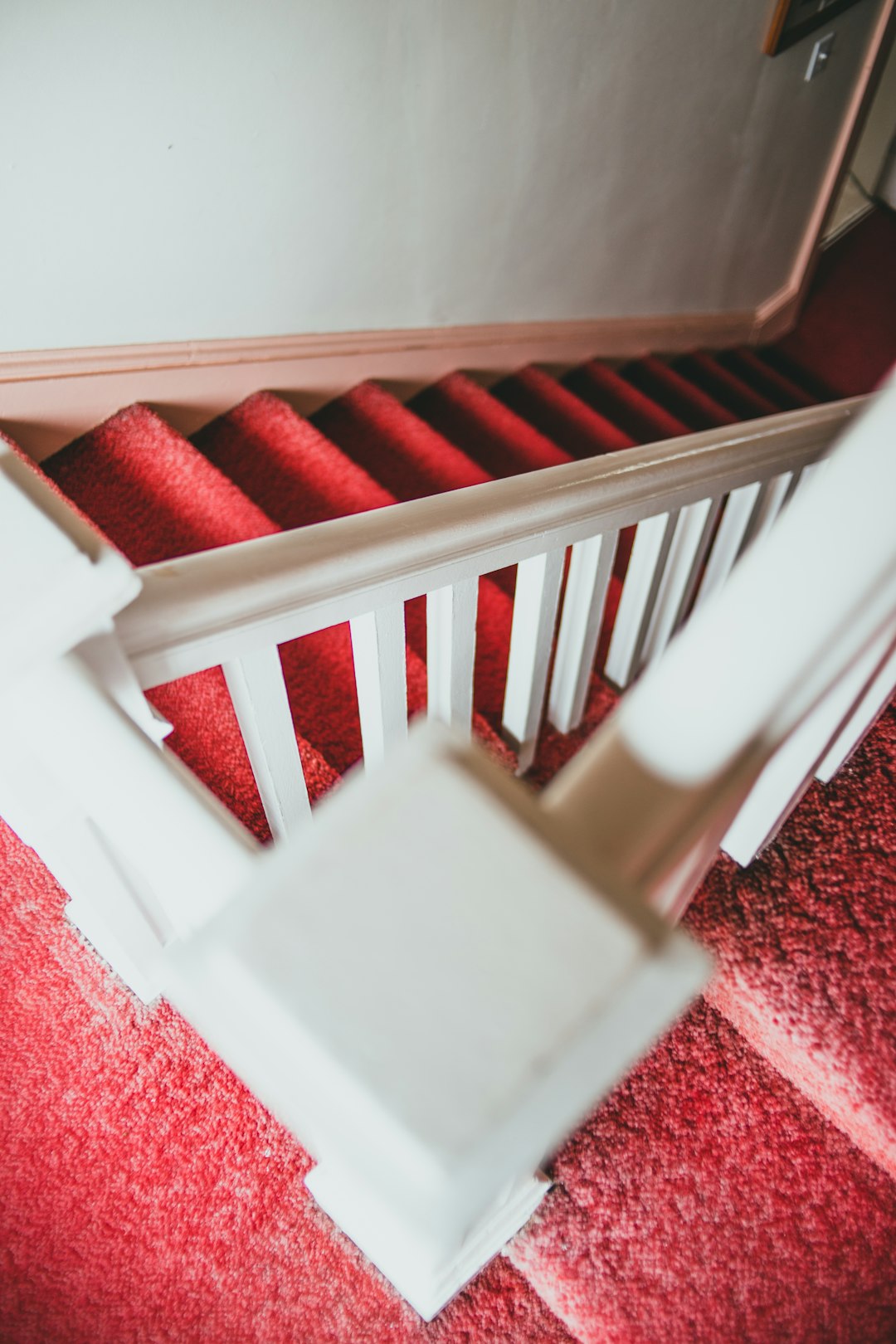 white wooden staircase on red carpet