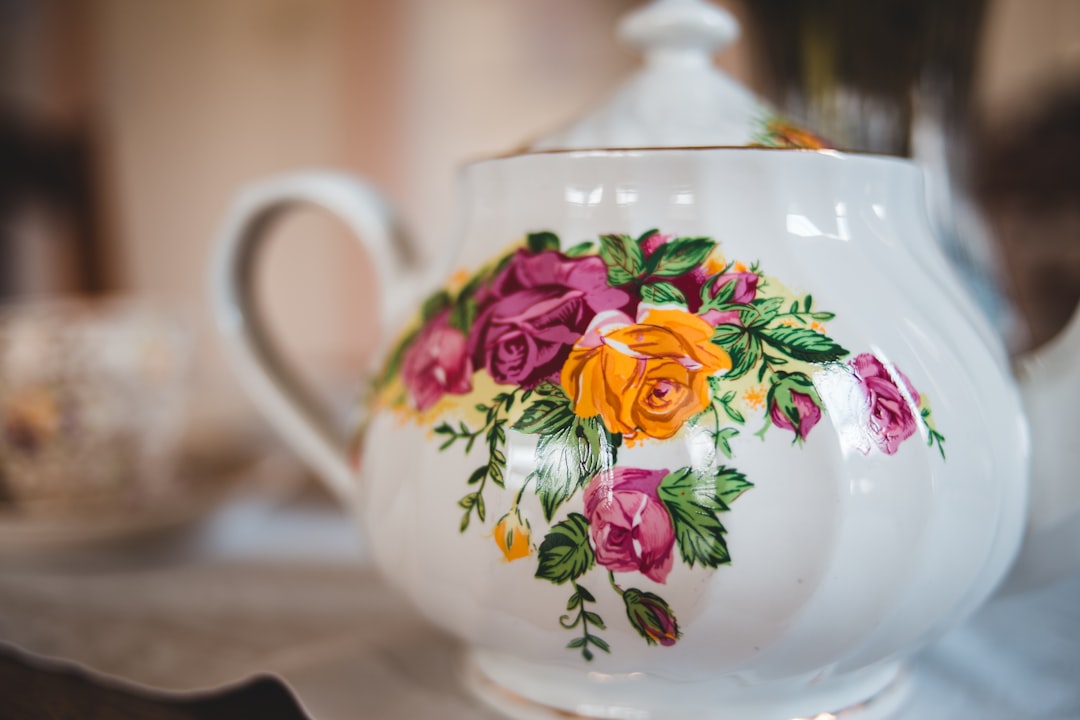 white and pink floral ceramic teapot